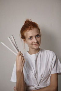 Portrait of young woman showing incense sticks