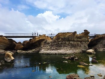 Rock formations by sea against sky