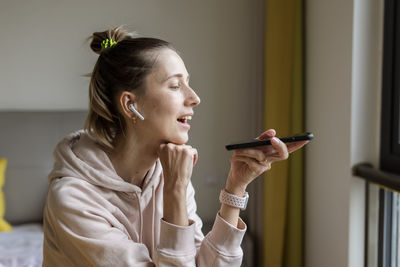 Woman talking on phone while sitting at home