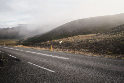 Empty road leading towards mountains