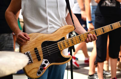 Midsection of man playing guitar