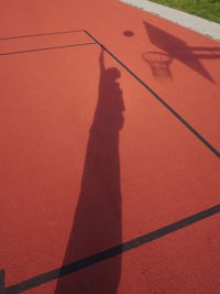 Shadow of man playing basketball on court