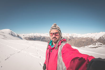 Man on snowcapped mountain against clear sky