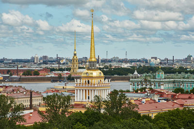 View of cityscape against cloudy sky