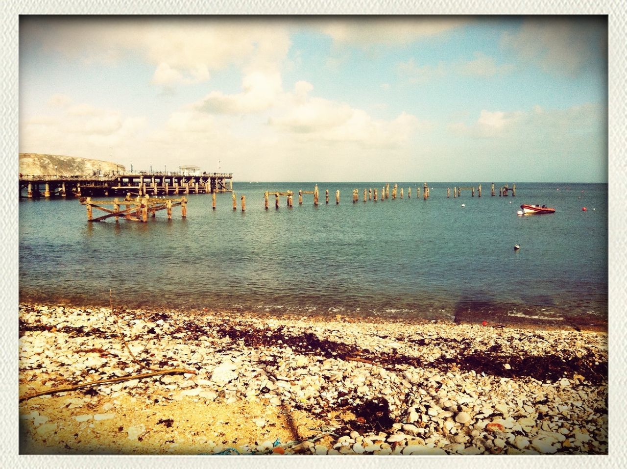 water, sea, sky, transfer print, beach, horizon over water, tranquil scene, tranquility, shore, auto post production filter, scenics, cloud - sky, beauty in nature, nature, pier, rock - object, sand, cloud, idyllic, day