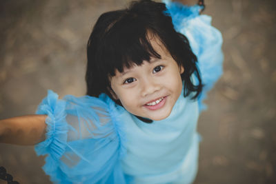 Portrait of smiling girl standing on footpath