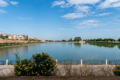 Scenic view of river by buildings against sky