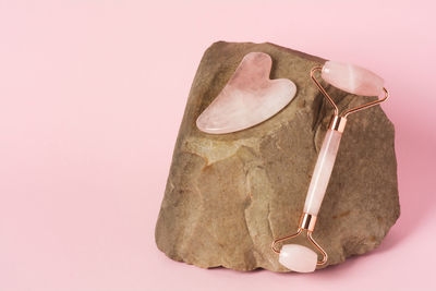 Roller and gua sha facial massage tools on natural stone. skin care, beauty and health concept. 