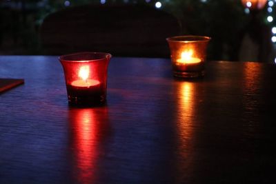 Close-up of lit tea light candle on table