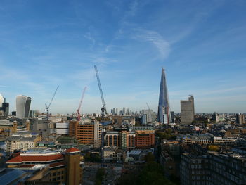 Buildings in city against cloudy sky