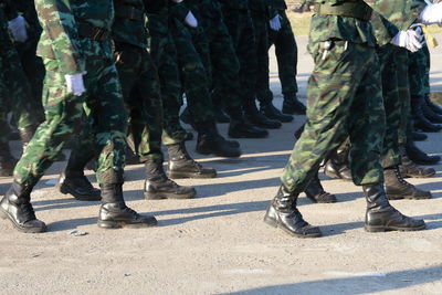 Low section of soldiers walking on road