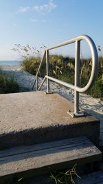 Railing by sea against sky