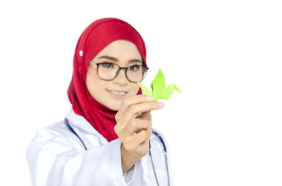 Portrait of smiling young woman against white background