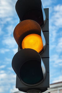 Low angle view of road signal against sky