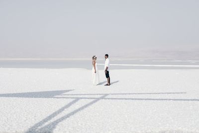 Rear view of couple standing against sky