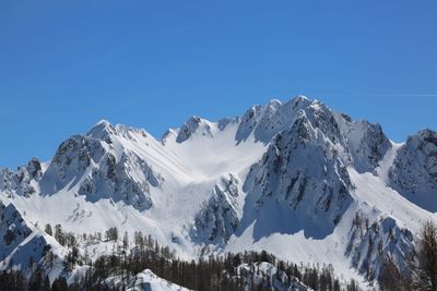 Wide panormaric view of moutains with white snow in winter from lussari mount in northern italy