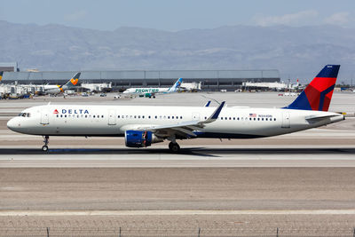 Airplane on airport runway against mountains