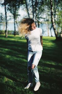 Full length of young woman against tree