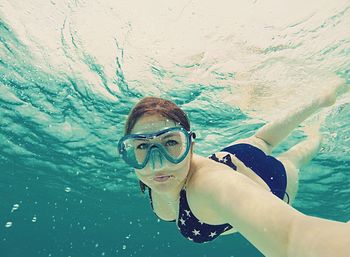 Portrait of woman wearing bikini swimming in sea