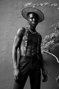 Portrait of young man standing against wall