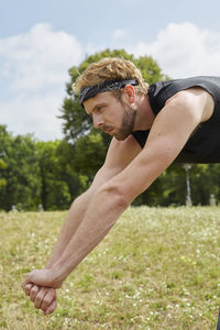 Side view of young man on field