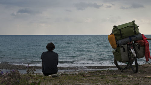 Rear view of people looking at sea against sky