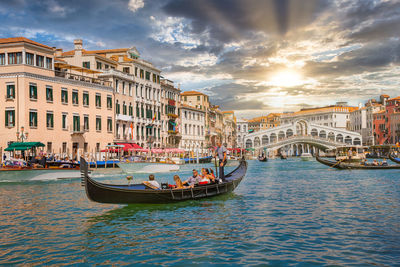 Venetian gondolier punting gondola through grand canal