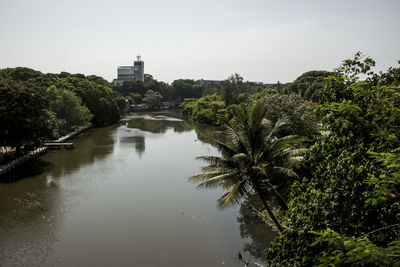 River amidst trees and buildings against sky