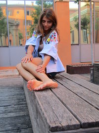 Portrait of woman sitting on wood