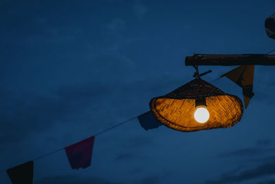 Low angle view of illuminated light against sky at dusk