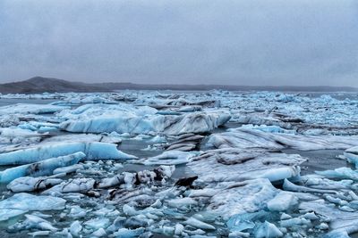 Scenic view of frozen lake against sky during winter