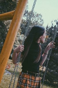 Woman standing on swing at playground