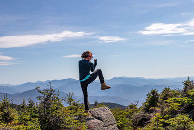 Man with umbrella against mountain range against sky