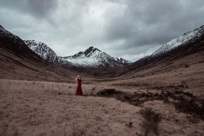 Woman standing on field against sky