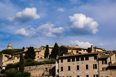 Low angle view of buildings against cloudy sky