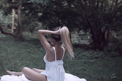 Woman wearing hat on field in forest