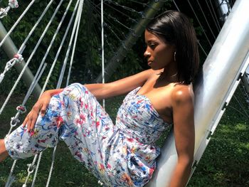 Young woman looking down while sitting outdoors