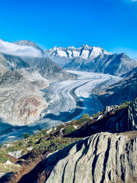 Scenic view of snowcapped mountains against blue sky