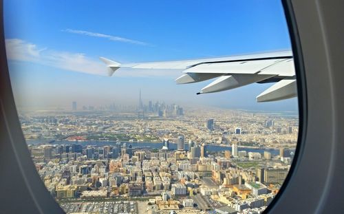 Cropped image of airplane flying over cityscape