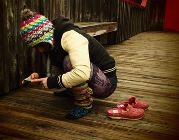 Side view of woman crouching on hardwood floor