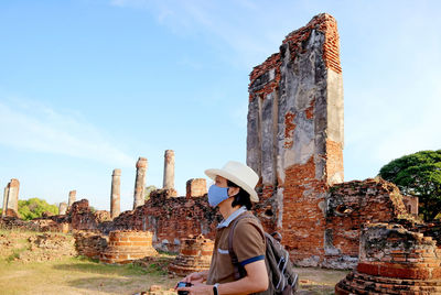 Visitor wearing face mask during a visit to wat phra si sanphet amid covid-19, ayutthaya, thailand