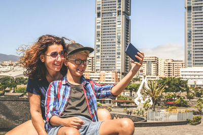 Young woman photographing with camera in city