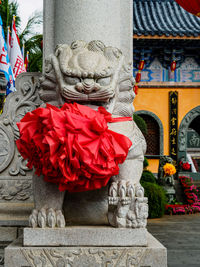 Close-up of buddha statue against red wall