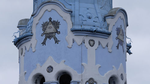 Low angle view of cross against building