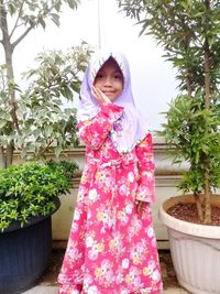 Portrait of smiling girl standing against plants