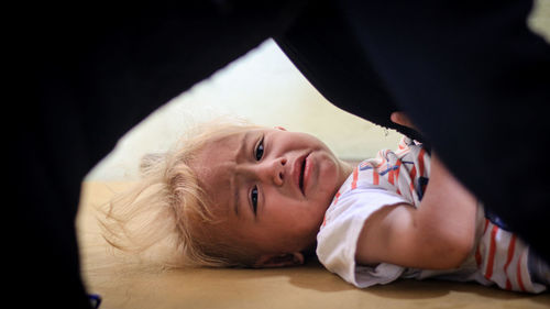 Portrait of boy lying down at home