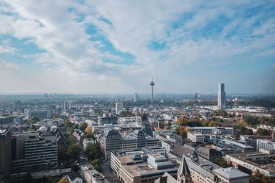 Aerial view of cityscape against cloudy sky