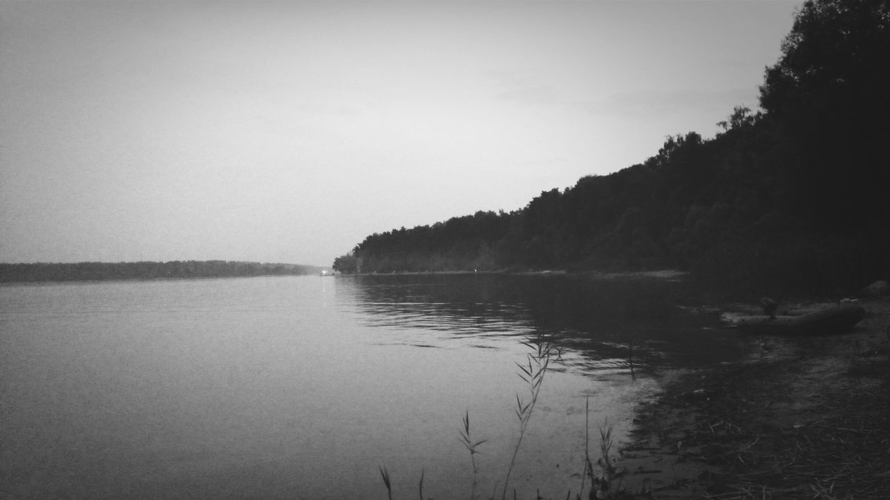 water, tranquil scene, tranquility, scenics, lake, beauty in nature, clear sky, reflection, nature, sky, idyllic, tree, copy space, waterfront, calm, mountain, non-urban scene, outdoors, no people, remote