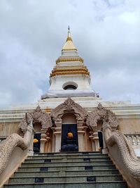 Low angle view of statues on building against sky