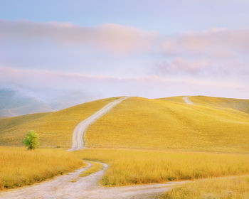 Road by landscape against sky